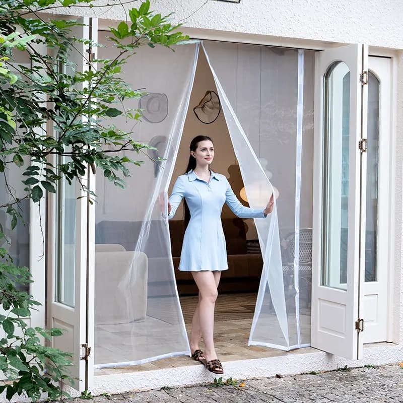 Person holding open a white magnetic screen door in a doorway